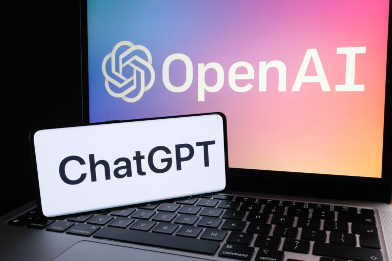 ChatGPT logo seen on smartphone and laptop display with blurred OpenAI company logotype. AI chatbot by OpenAI. Stafford, United Kingdom, December 20, 2022